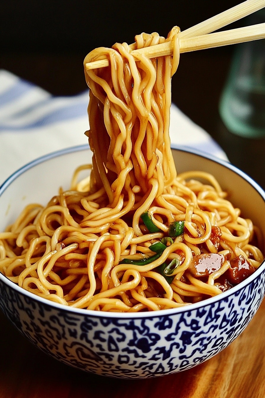 Noodles being tossed in a hot wok with soy garlic sauce