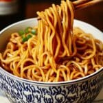 Hibachi noodles in a bowl with sesame seeds and chopped scallions