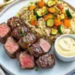 Hibachi steak with rice and veggies on a white plate tasty