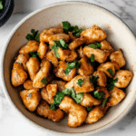 Chicken cooking in a cast iron skillet with steam rising
