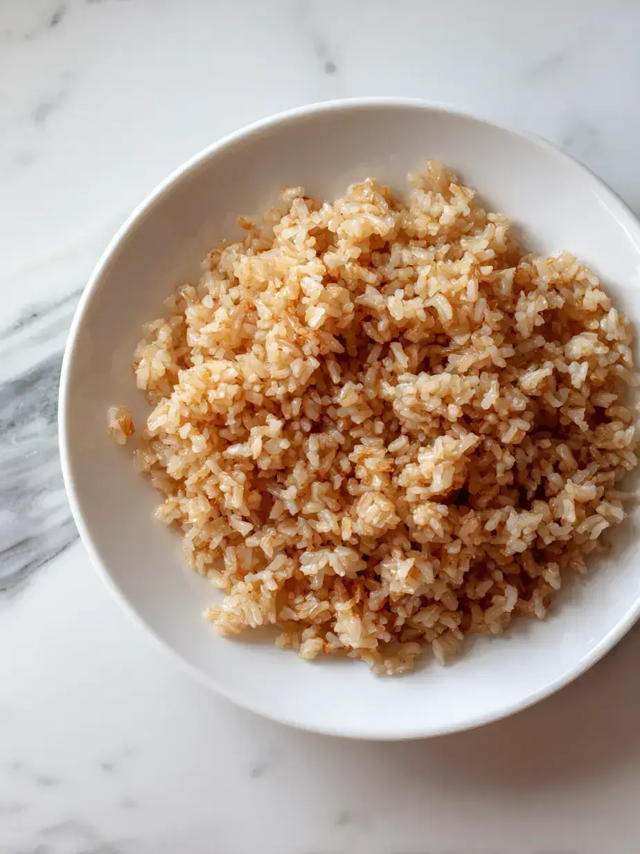Fluffy and perfectly cooked baked brown rice in a ceramic dish, ready to be served as a healthy side.